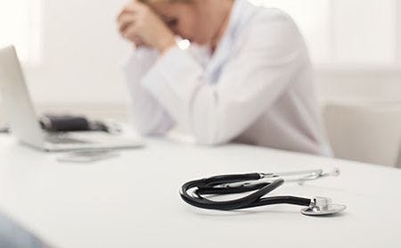 veterinary-tired-sad-female-doctor--desk-stethoscope-AdobeStock_198075823-450.jpg
