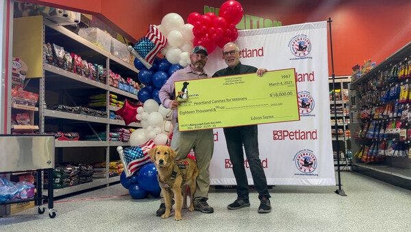 Petland Charities Executive Director presents $18,000 grant to Heartland Canines for Veterans Executive Director Jimmy Burgess. (Image courtesy of Petland) 